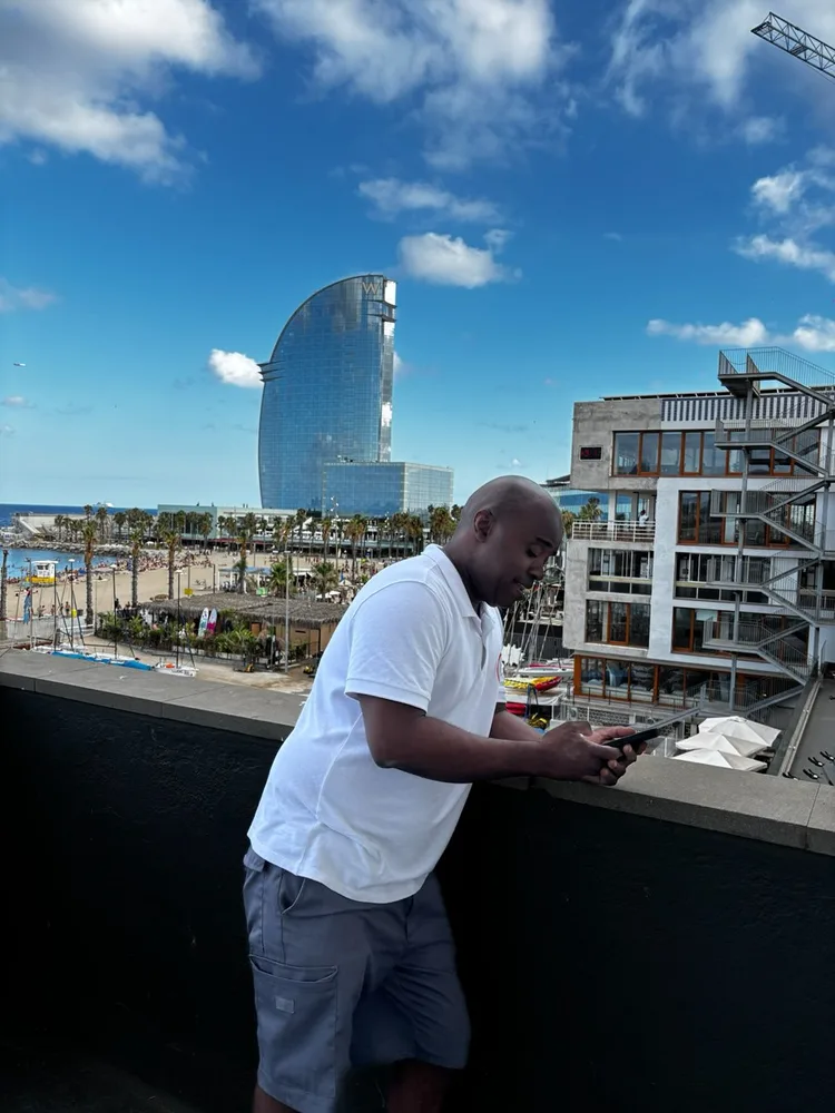 Empleado de Servicios24 en la terraza del Club Natació Barcelona, con el hotel W Barcelona al fondo