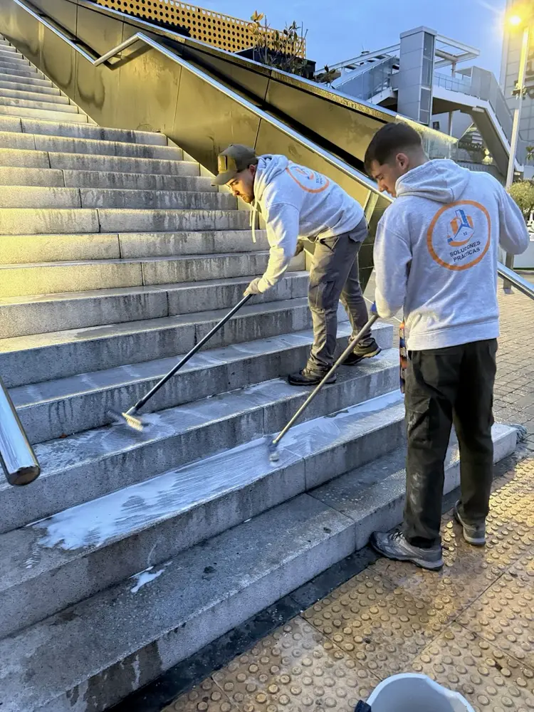 Empleados de Servicios24 limpiando los escalones de acceso de The Style Outlets Madrid